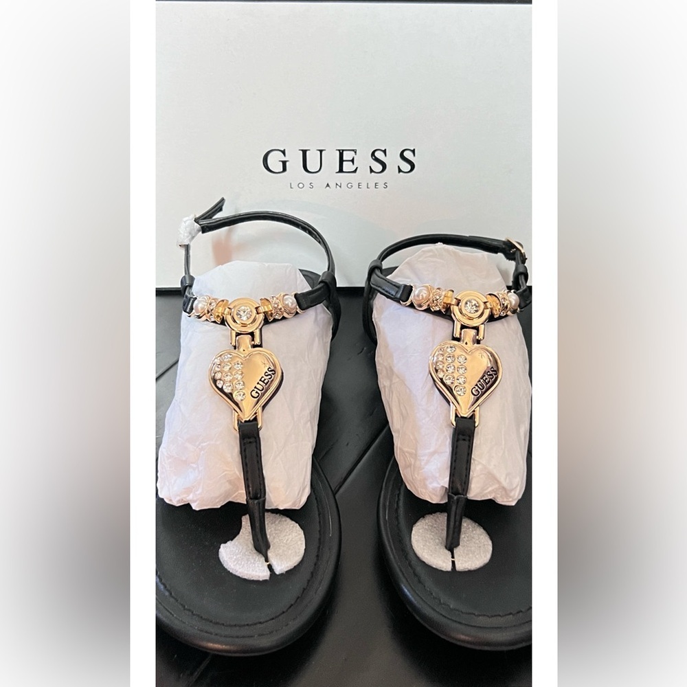 Beautiful Guess Women’s T-Strap Sandal with gold hardware accents.